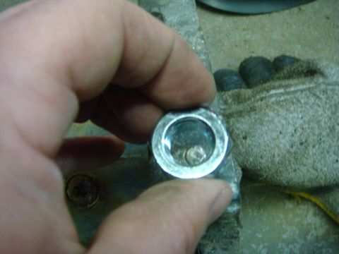 1996 Ford Bronco - A close-up view of a metal component with a damaged bolt, being handled by a person.