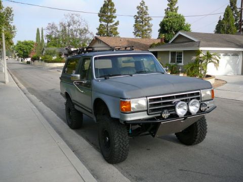 1988 Ford Bronco - This modified Ford Bronco features an aftermarket bumper and auxiliary lights, with a roof rack installed.