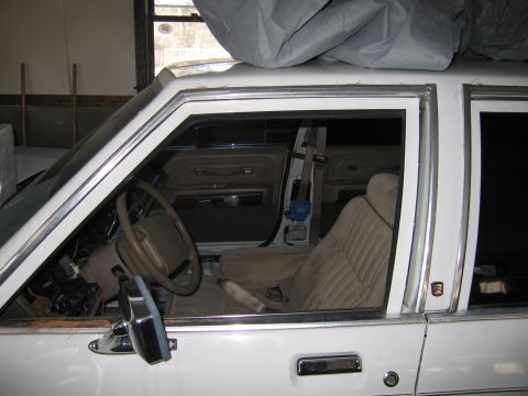 1991 Ford LTD Crown Victoria - The interior of a white sedan is shown, tan upholstery and a view of the dashboard and driver's seat.