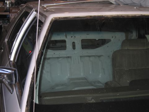 1991 Ford LTD Crown Victoria - The interior of a 1991 Ford Crown Victoria LTD, stripped down to the metal in the rear, with visible seats.