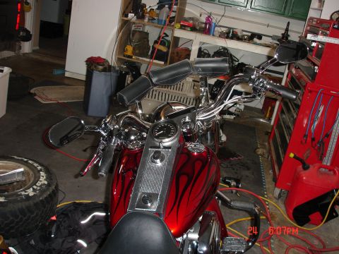 2006 Harley-Davidson FLHX - A red motorcycle with black flame graphics is parked in a garage.