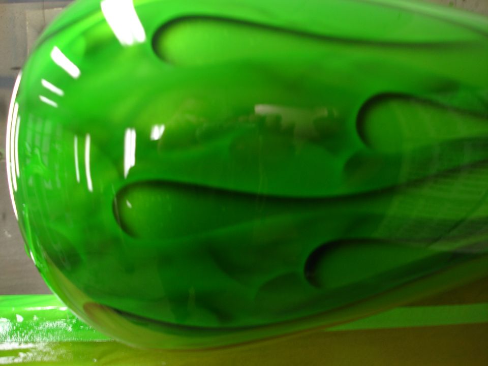 Close-up of candy-green paint with airbrushed ghost flames on a motorcycle tank