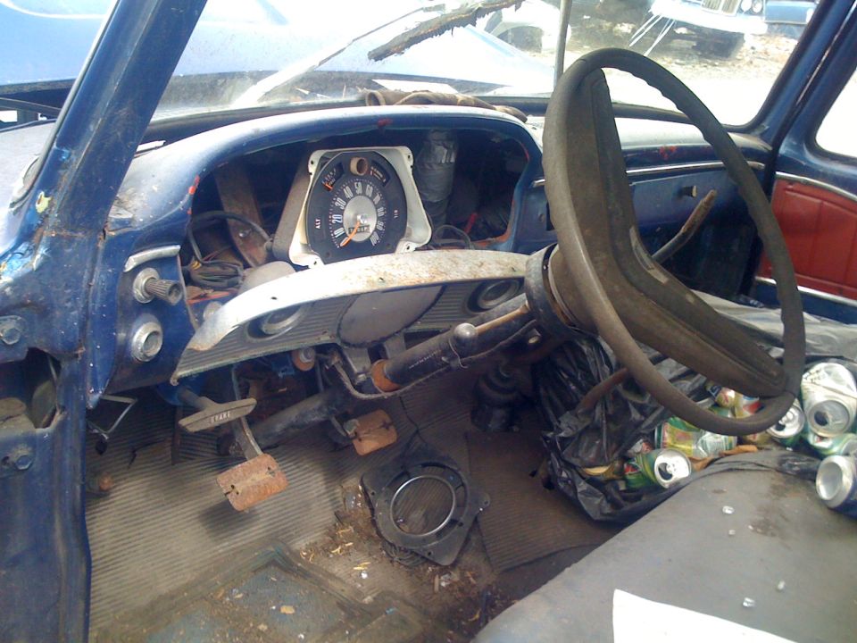 Stripped, rusty interior and dashboard of an old pickup truck