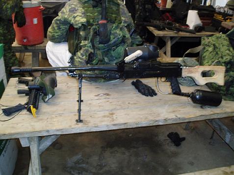 1985 Ford Bronco - A paintball marker with a wooden stock and an air tank is displayed on a wooden table.