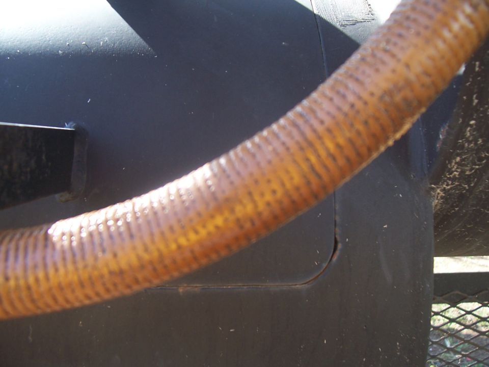 Corrugated hose over black metal surface