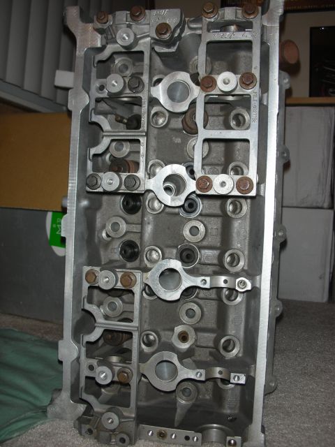 1998 Ford Crown Victoria - Top-down view of an aluminum cylinder head revealing rocker arms, valve lifters, and numerous bolt holes.
