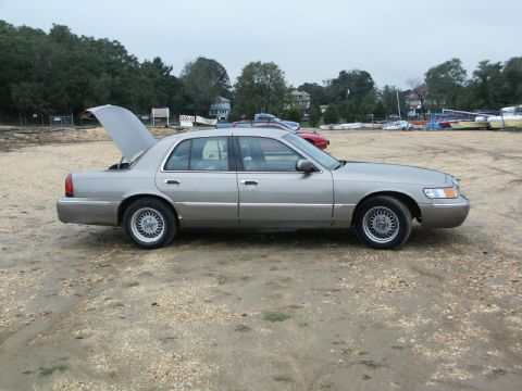 2001 Mercury Grand Marquis - A silver 2001 Mercury Grand Marquis sedan is parked on a gravel lot with its trunk open.