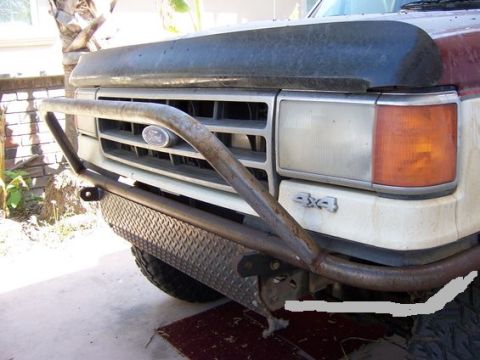 1989 Ford Bronco - Front view of a modified Ford Bronco, showing its grille, headlights, and custom bumper.