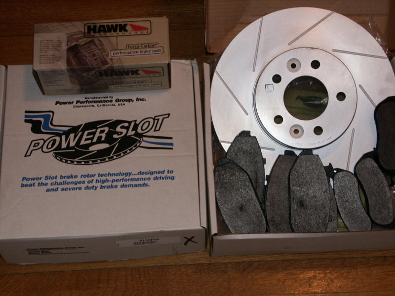 Slotted Power Slot rotor and Hawk brake pads in boxes on wood floor