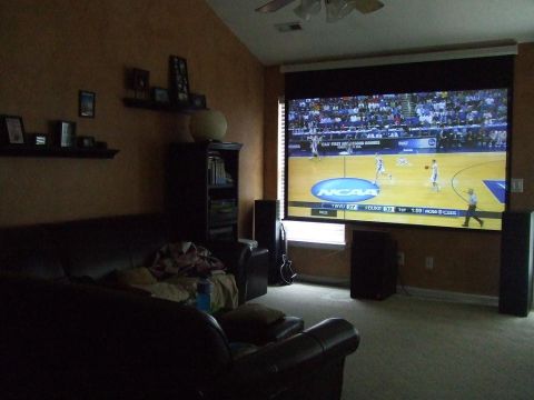 1987 Ford Bronco - Projector screen displays an NCAA basketball game in a living room with couches and shelves.