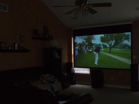 1987 Ford Bronco - A living room with a projector displaying a golf match on a large screen.
