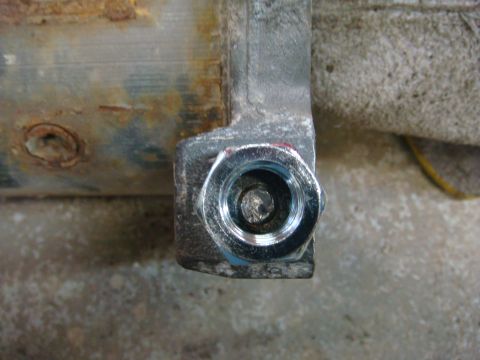 1996 Ford Bronco - A close-up view of a metal bracket with a bolt, showing signs of rust and wear.