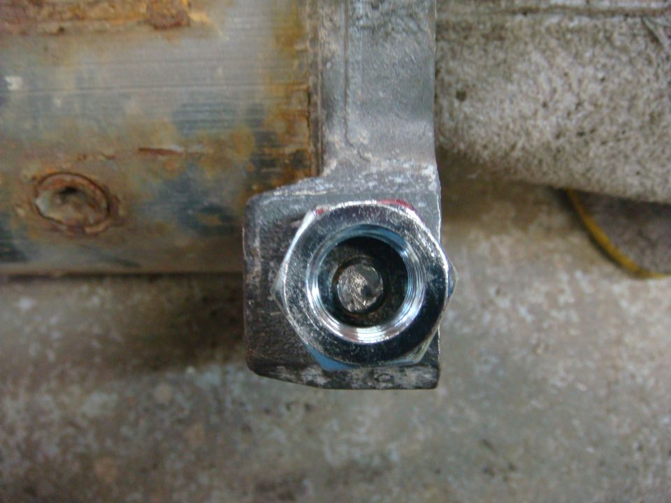 Close-up of a rusty metal bracket with a shiny bolt head