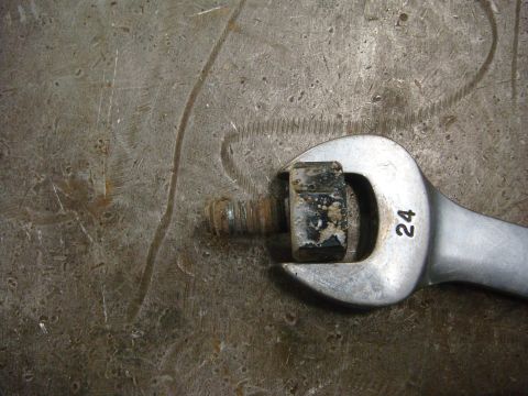 1996 Ford Bronco - A 24mm wrench is used to turn a bolt head that has some debris on it.
