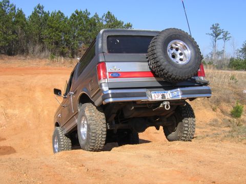 1989 Ford Bronco - This 1989 Ford Bronco is tackling an off-road trail, showing its rear end and spare tire.
