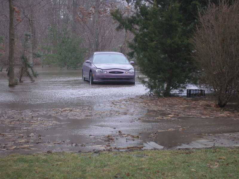 Purple 1997 Ford Taurus front view, partially submerged in floodwater
