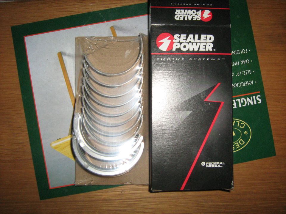 New Sealed Power engine bearing shells with their box on a wood table