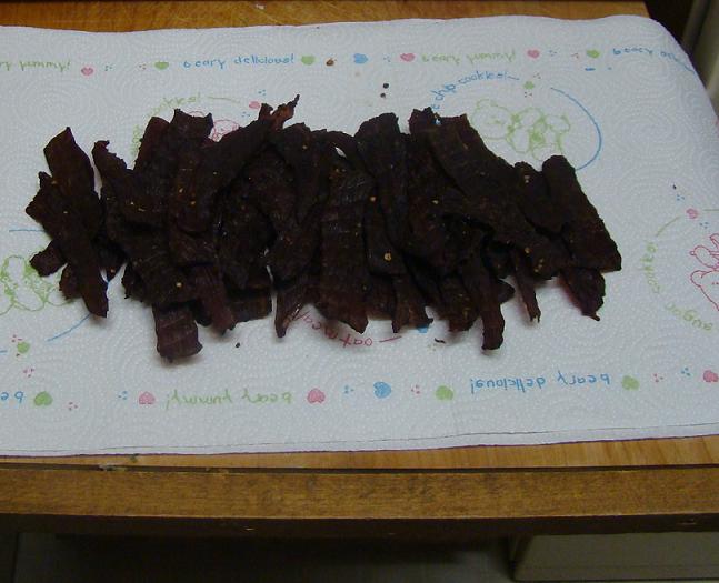 pile of beef jerky strips on a paper towel with bear drawings