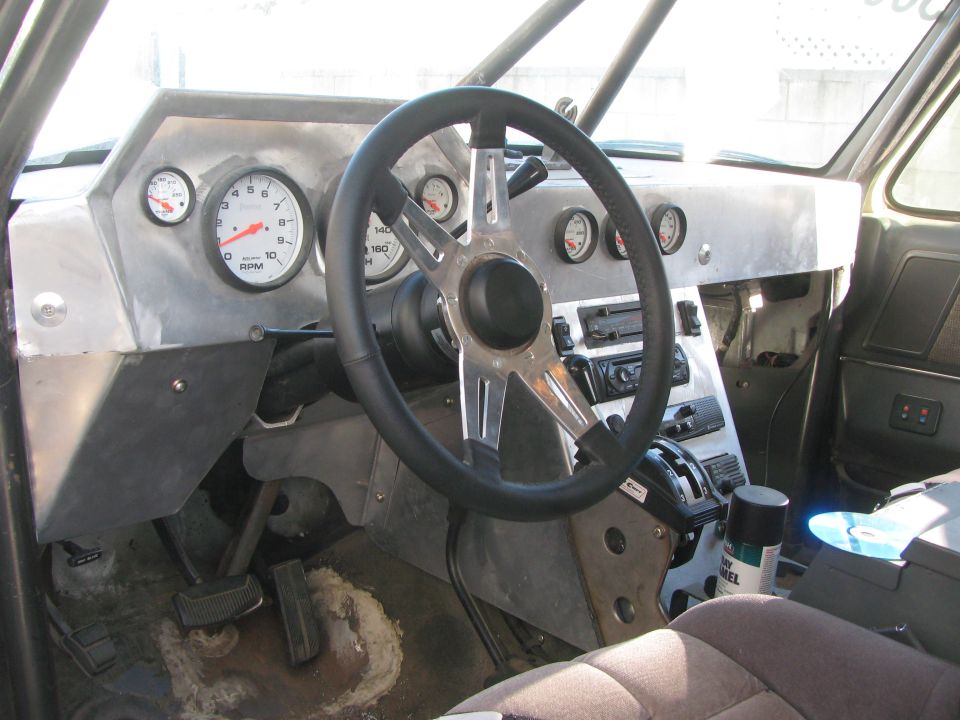 Custom interior with steering wheel, tachometer and round gauges on aluminum dash