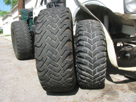 1987 Suzuki Samurai - Close-up of two different sized off-road tires on a vehicle's axle.