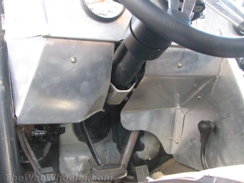 1990 Ford Bronco - Vehicle cabin interior showing the steering column, pedals and unfinished aluminum panels around the transmission tunnel.
