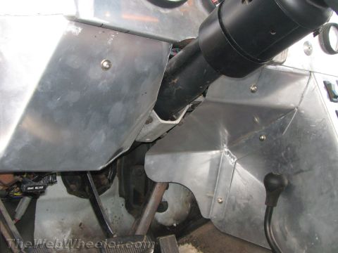 1990 Ford Bronco - Close-up of a custom vehicle interior showing the steering column, shift lever and riveted aluminum panels.