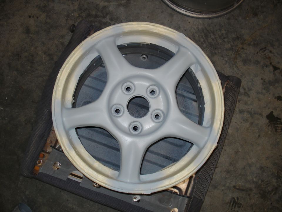 Gray 5-spoke wheel with masking tape on the rim