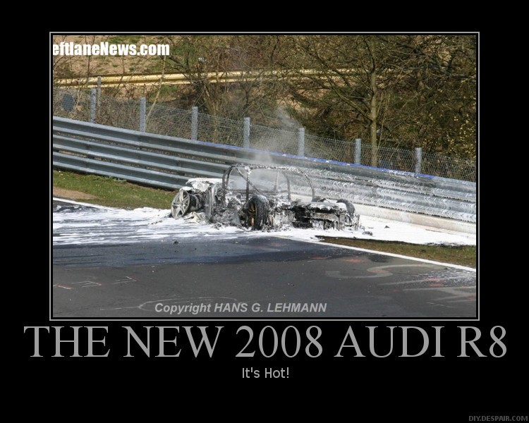 Burnt car covered in foam on a race track, smoke rising