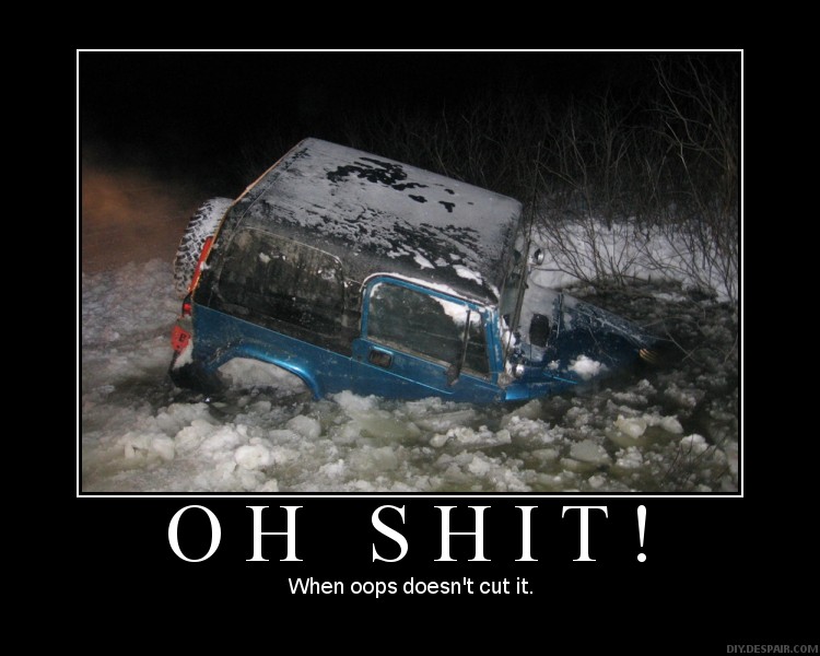 Blue SUV stuck in snow, rear spare tire visible, dark night scene