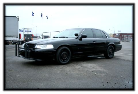 1998 Ford Crown Victoria - Black 1998 Ford Crown Victoria sedan with a push bumper is parked outdoors.