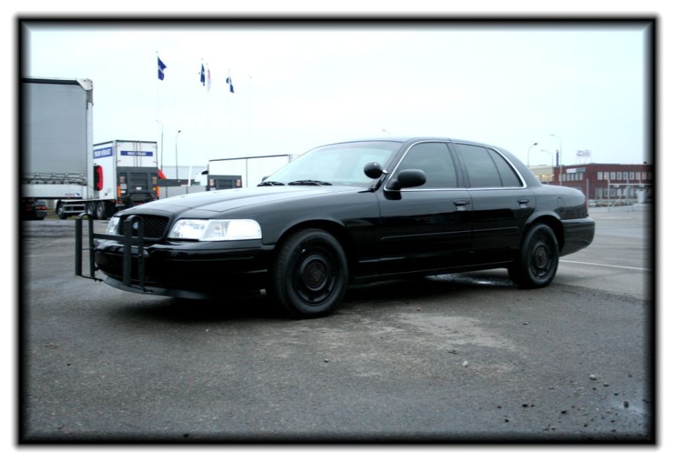 Black 1998 Ford Crown Victoria with a push bumper parked on asphalt