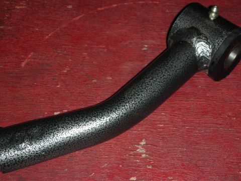 1998 Ford Crown Victoria - curved metal tube with a wrinkle-black coating and a barbed fitting lies on a worn red workbench.