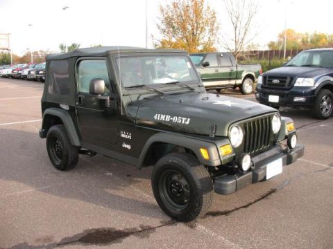 1993 Ford Bronco - A dark green Jeep Wrangler is parked in a lot with other vehicles visible in the background.