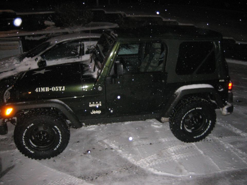 Green Jeep Wrangler in snow with 'Willys Jeep' badge and '41MB-05TJ' text