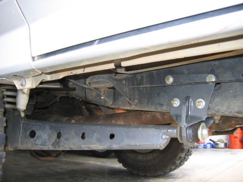 1989 Ford Bronco - The underside of the vehicle reveals its frame and suspension system, with a portion of the tire visible.