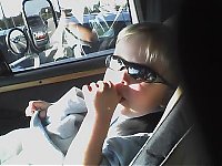 1993 Ford C-350 (Centurion Conversions) - Child in sunglasses looks out the window of a vehicle.