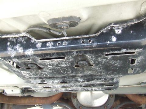 2003 Ford Crown Victoria - Underside view of a vehicle's underbody, showing a metal shield and wiring.