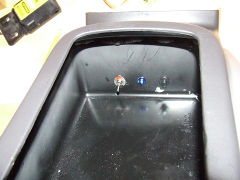 2003 Ford Crown Victoria - Close-up of a vehicle's interior console showing a toggle switch and a blue LED light.