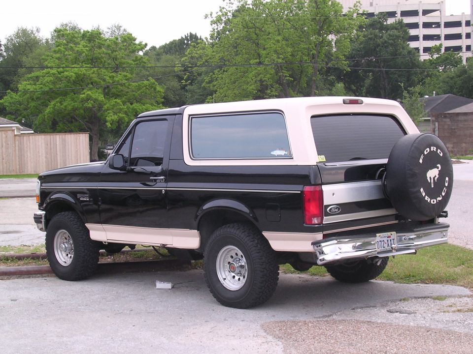 Black and tan Ford Bronco SUV rear 3/4 view with Ford Bronco spare tire cover