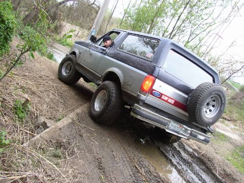 1989 Ford Bronco - This 1989 Ford Bronco navigates a challenging muddy terrain, its off-road capabilities.