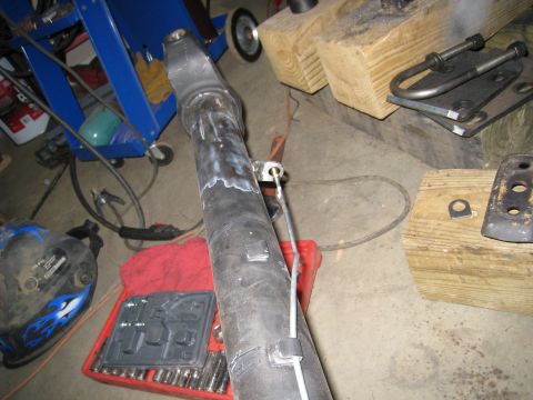 1996 Ford Bronco - A driveshaft with fresh welds and a cable guide is shown in a workshop setting.