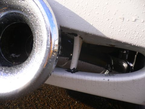1999 Ford Crown Victoria - Close-up of a chrome tow hook attached to a white bumper, showing water droplets on the surface.