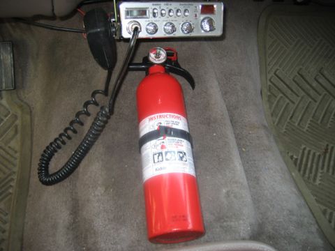 1995 Ford Bronco - A fire extinguisher and CB radio are mounted on the floor of a vehicle's interior.