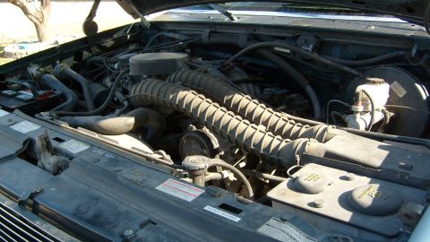 1995 Ford C-150 (Centurion Conversions) - View of the engine compartment, showing the dual intake hoses and brake fluid reservoir.