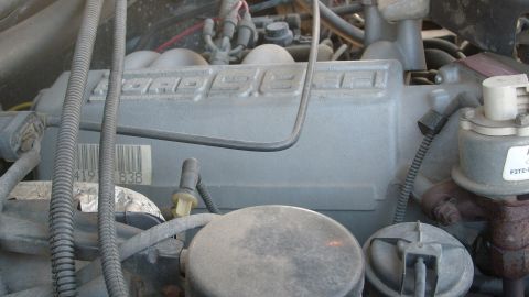 1995 Ford C-150 (Centurion Conversions) - The engine compartment of a 1995 Ford C-150 (Centurion Conversions) displays the "FORD" embossed engine block.