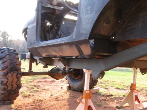 1980 Jeep CJ7 - The vehicle is elevated on jack stands, revealing its chassis and drivetrain components.