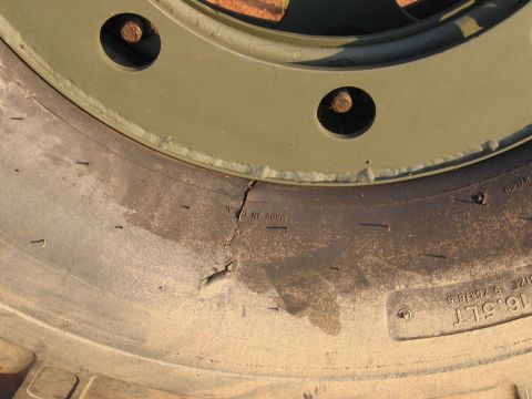 1980 Jeep CJ7 - A close-up view of a damaged tire and wheel assembly.
