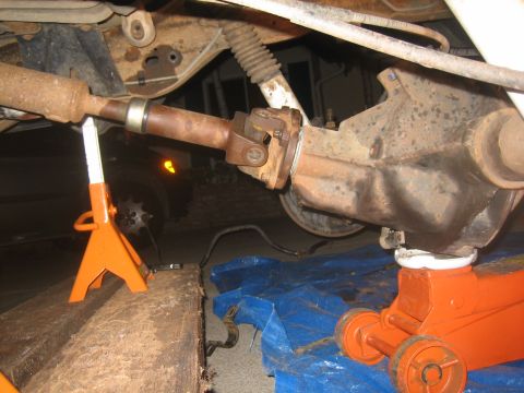 1995 Ford Bronco - Close-up view of a vehicle's rear axle and driveshaft assembly, undergoing maintenance.