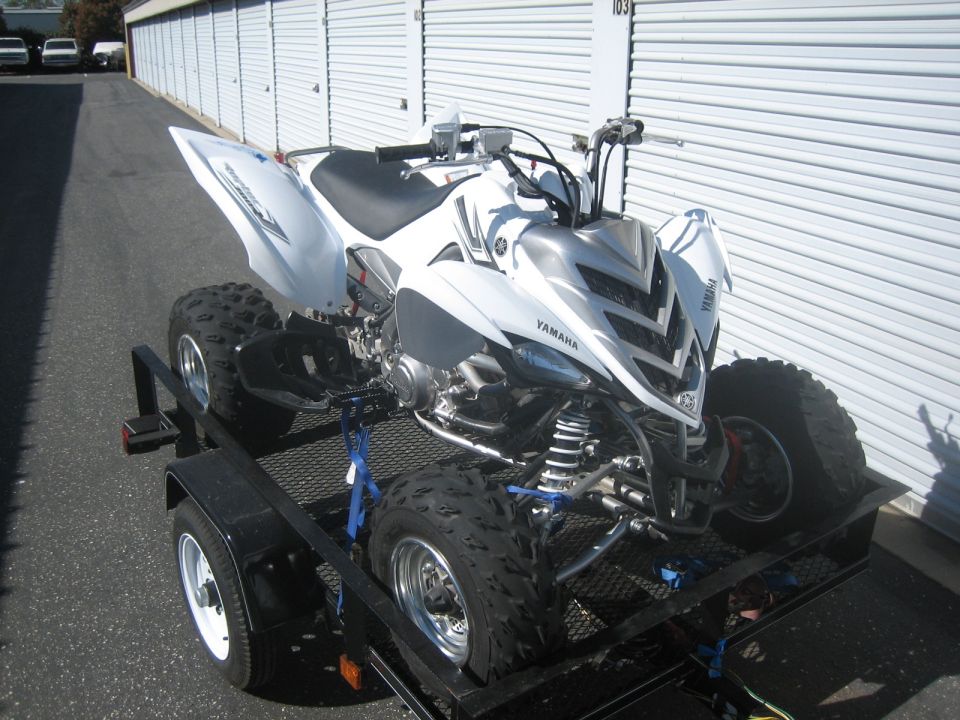 White Yamaha ATV on trailer, front 3/4 view