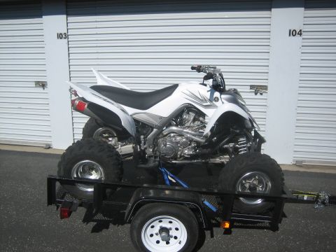 1995 Ford Bronco - A white ATV is secured to a trailer in front of a row of storage unit doors.